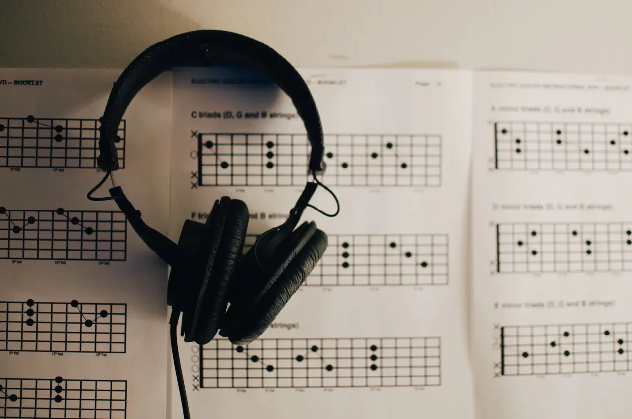 headphones resting on sheets of guitar diagrams all about triads
